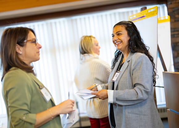 Two people talking in front of poster boards