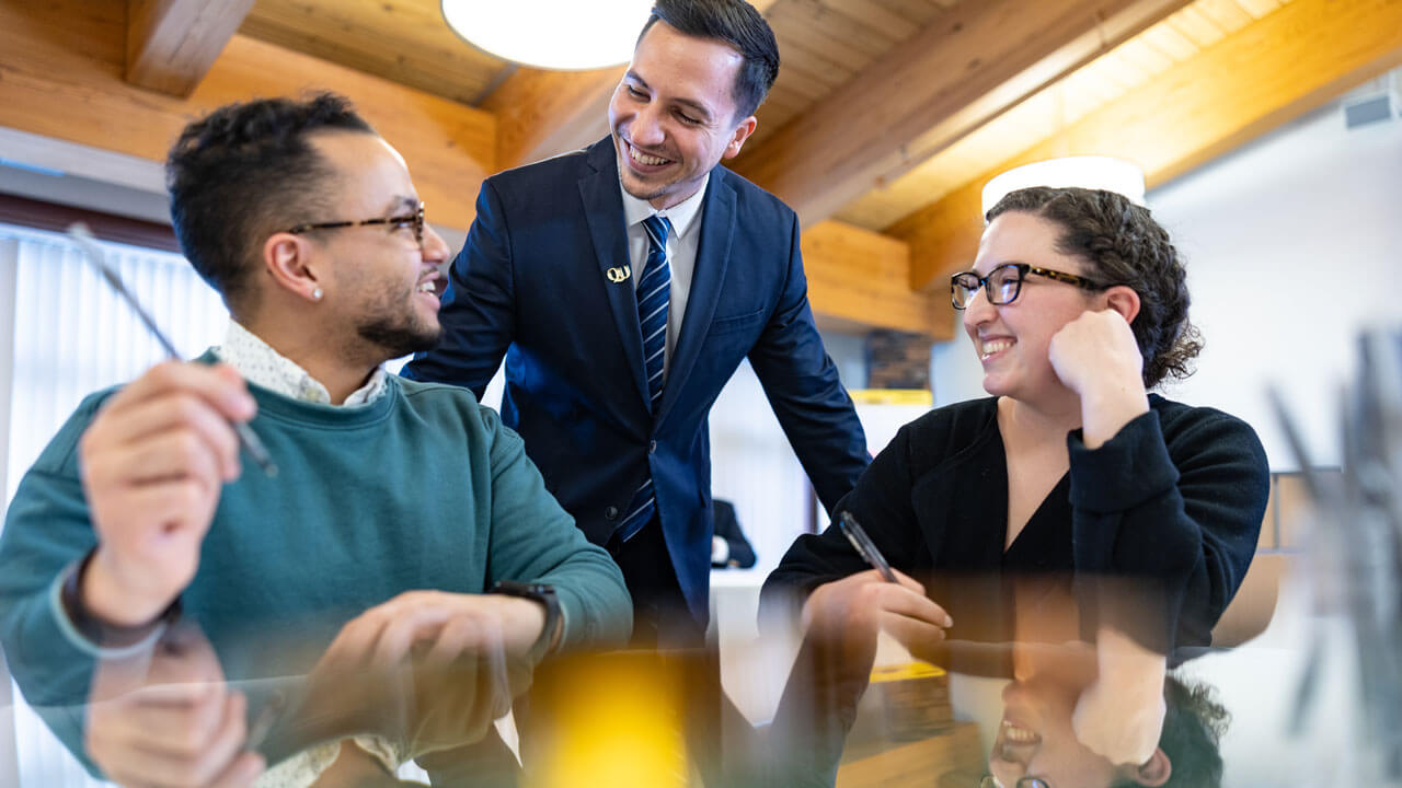 Professionals sit at a table smiling while talking