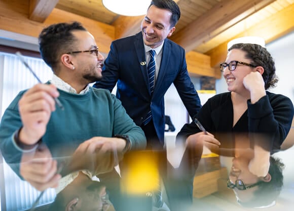 Professional learners sit at a table smiling while talking