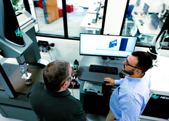 aerial view of two men at a computer in a manufacturing company
